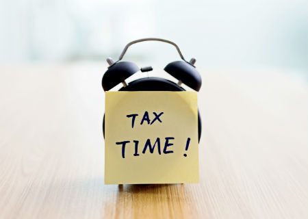 Alarm clock with Tax Time written on a note