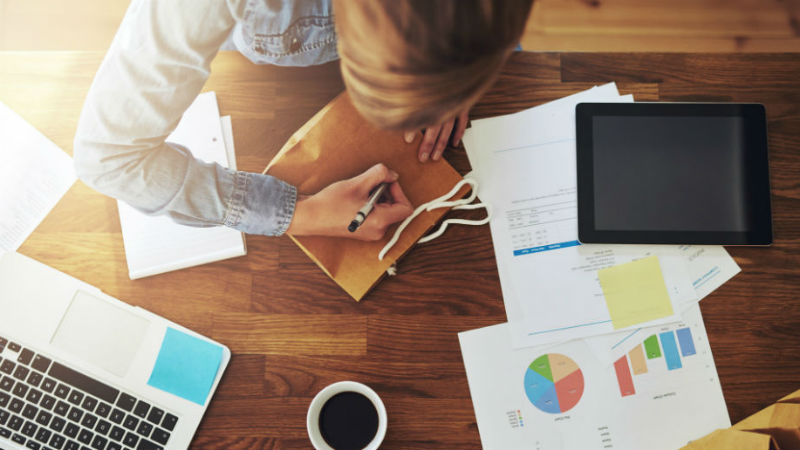 Woman writing notes from above