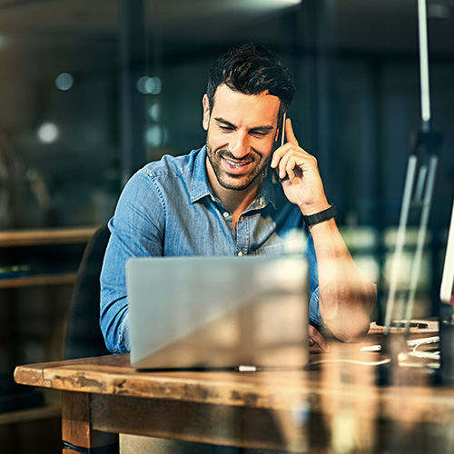 Man with laptop on phone