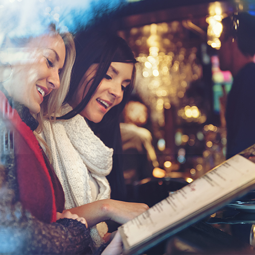 Women looking at a menu in a bar
